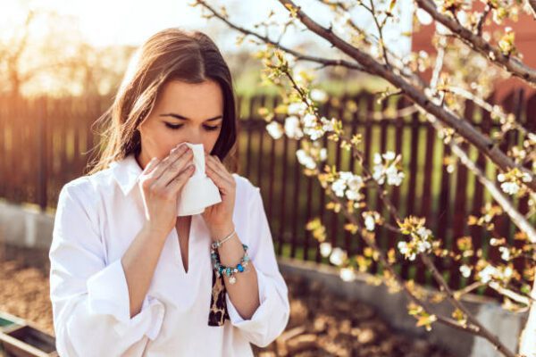 Young adult woman coughing and sneezing outdoors. Sick people allergy or virus influenca concept.