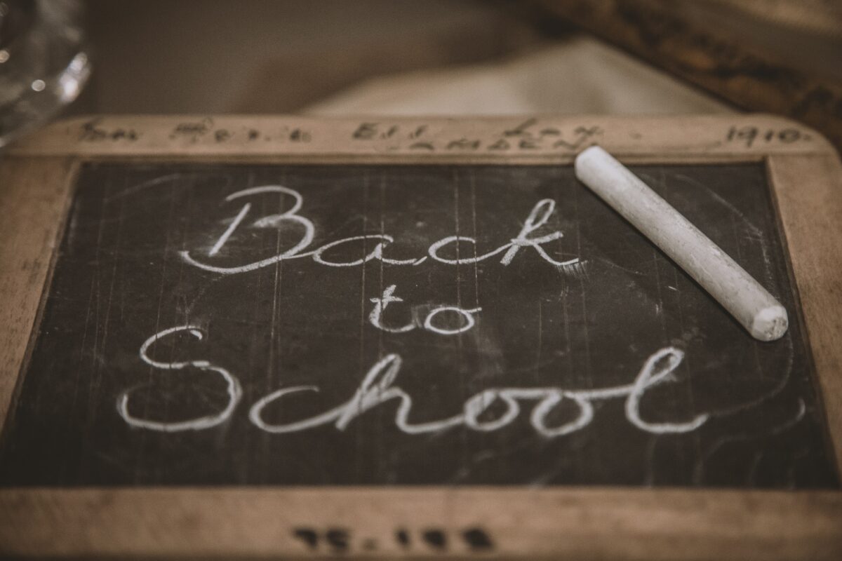 Small chalkboard with "Back to school" written on it and a stick of chalk sitting on the side