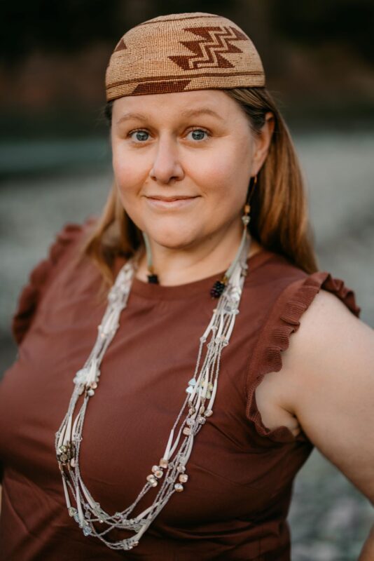 Photo of woman in maroon top with long necklace and traditional headpiece