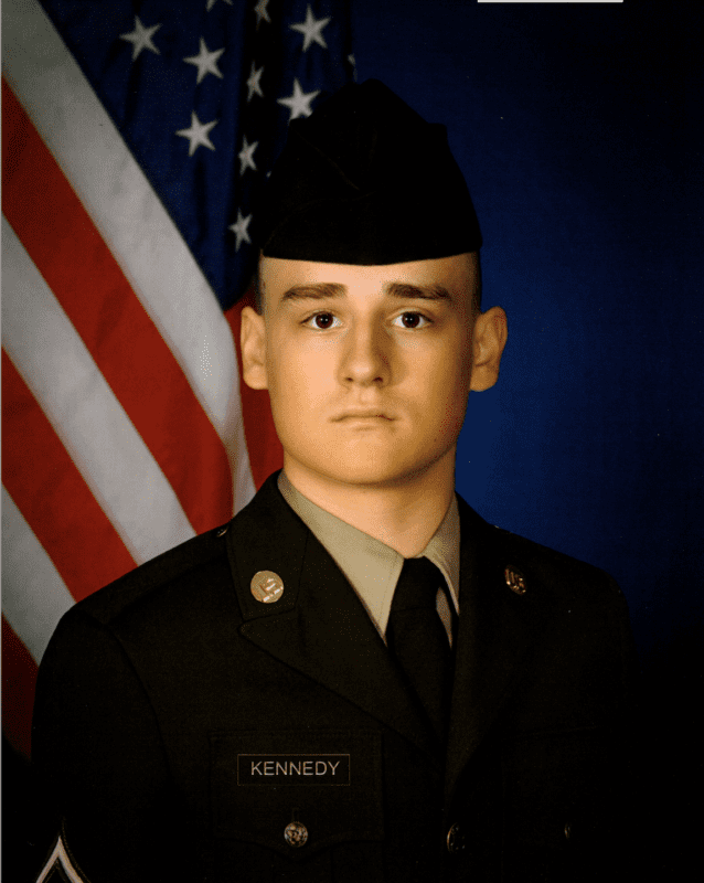 Headshot of Jackson Kennedy in Army National Guard uniform with American flag in background