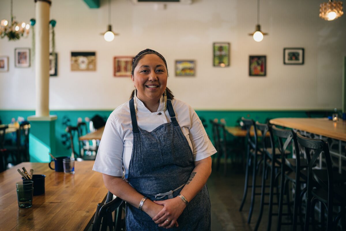 Photo of woman in a chef apron standing in a restaurant